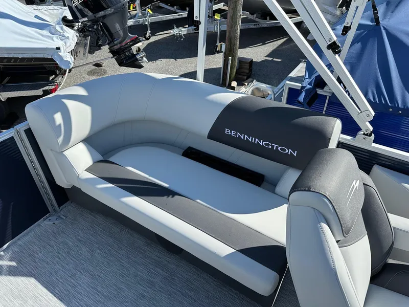 Slide: The Image of 2025 Bennington 20 SSR Quad Bench boat interior with gray seating and logo. - 27
