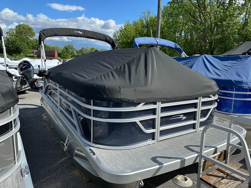 Slide: The Image of 2025 Bennington 20 SSR Quad Bench pontoon boat with cover, parked outdoors. - 31