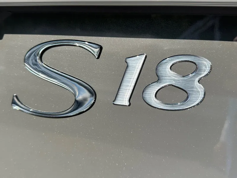Slide: The Image of Close-up of 'S18' emblem on 2025 Bennington 188 SL Family boat. - 18