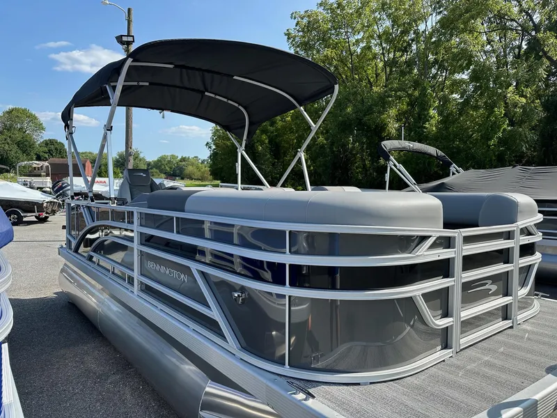 Slide: The Image of 2025 Bennington 188 SL Family pontoon boat with canopy, parked outdoors. - 20