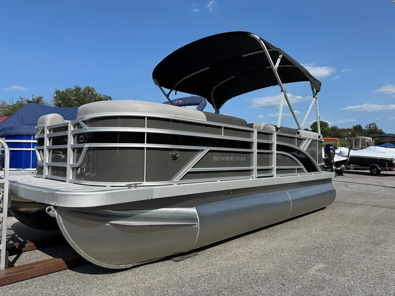 Slide: The Image of 2025 Bennington 188 SL Family pontoon boat with canopy, in stock, displayed outdoors. - 27