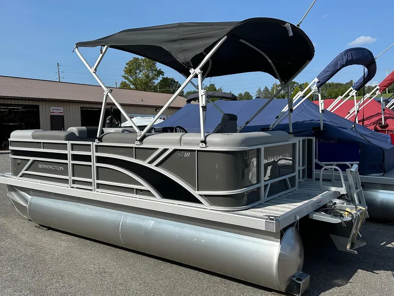 Slide: The Image of 2025 Bennington 188 SL Family pontoon boat with canopy, displayed outdoors. - 3