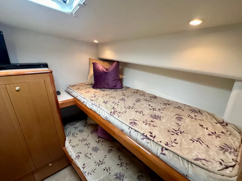 Slide: The Image of Bunk beds in 2000 Viking 65 Sport Fisher cabin with floral bedding and wooden cabinetry. - 10