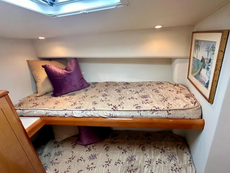 Slide: The Image of Cozy cabin interior of 2000 Viking 65 Sport Fisher with floral bedding and decorative pillows. - 11