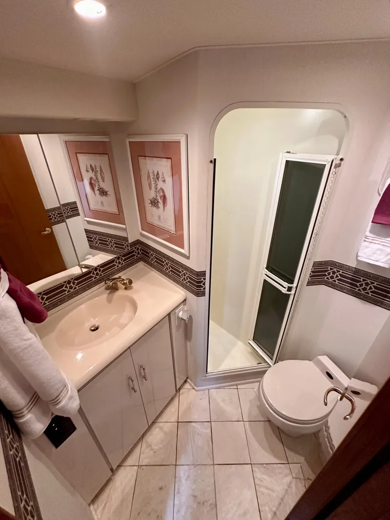 Slide: The Image of Bathroom interior of 2000 Viking 65 Sport Fisher yacht, featuring sink, toilet, and shower. - 14