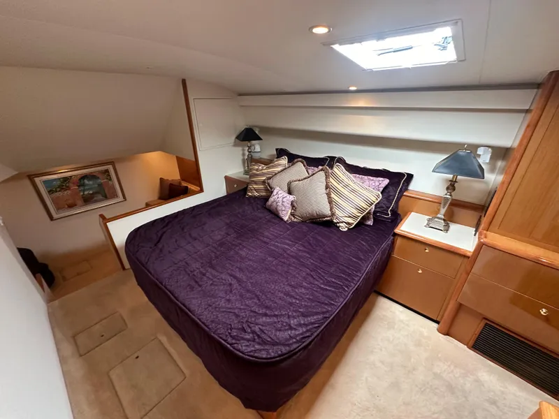 Slide: The Image of Luxurious bedroom in 2000 Viking 65 Sport Fisher yacht with purple bedding and elegant decor. - 6