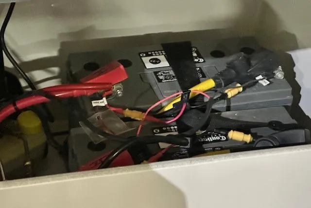 Slide: The Image of Battery compartment of 2024 Crownline 240 SS boat with connected cables. - 15