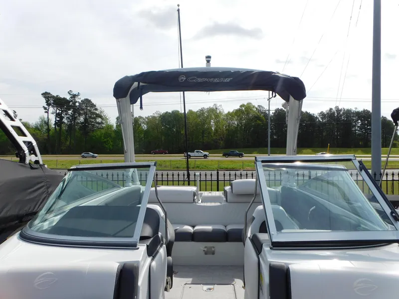 Slide: The Image of 2024 Crownline 240 SS boat in showroom, front view, under indoor lighting. - 2