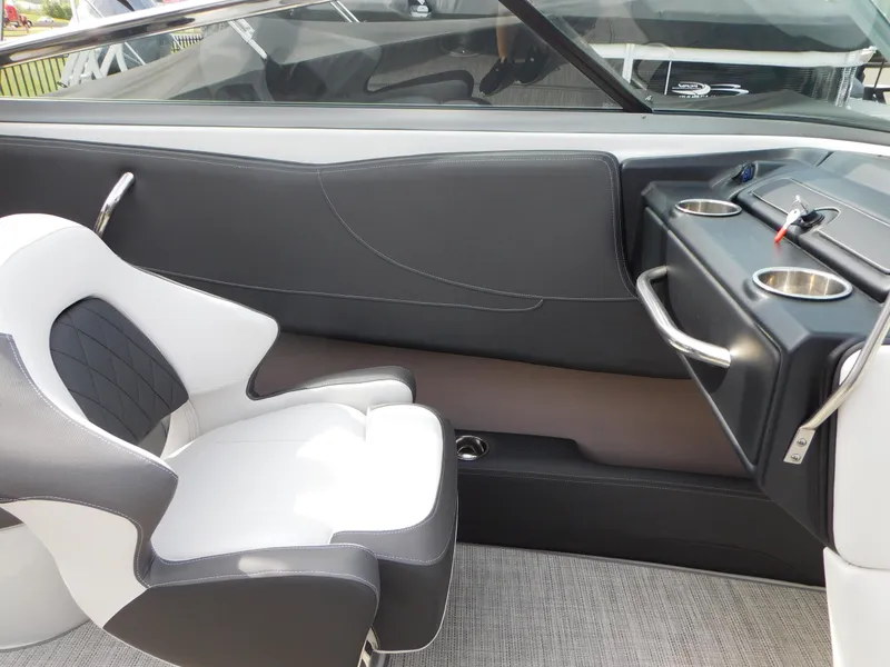 Slide: The Image of 2024 Crownline 240 SS boat interior with modern seating and dashboard in showroom. - 6
