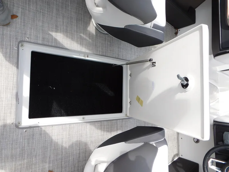 Slide: The Image of 2024 Crownline 240 SS boat interior storage compartment with open hatch. - 9