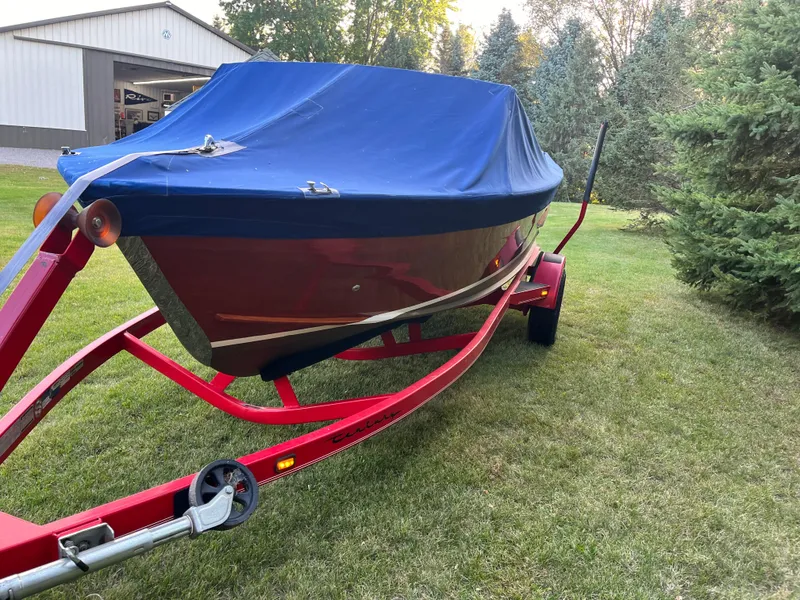 Slide: The Image of 1966 Century Arabian boat with blue cover on red trailer, parked on grass. - 17
