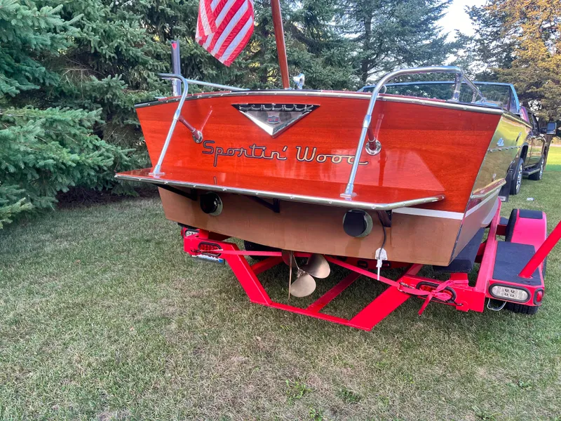 Slide: The Image of 1966 Century Arabian boat on trailer, wooden finish, American flag, outdoors. - 4