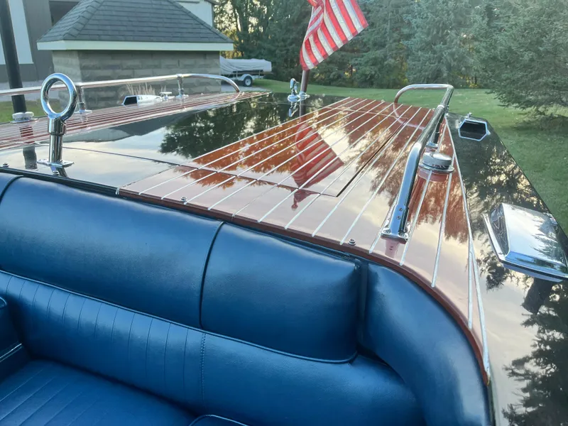 Slide: The Image of 1966 Century Arabian boat with polished wood deck and blue interior, featuring an American flag. - 8