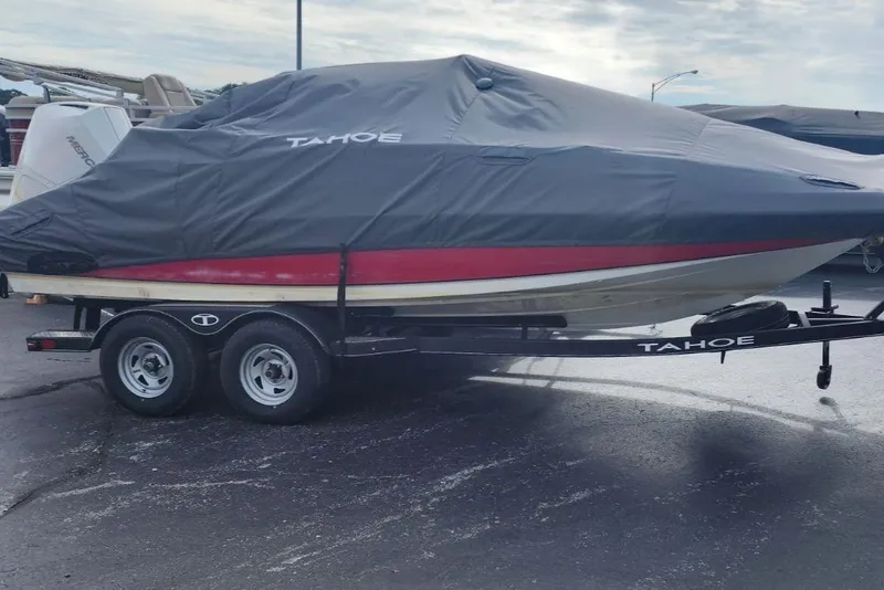 Slide: The Image of 2022 Tahoe 2150cc boat covered on trailer, parked outdoors. - 1