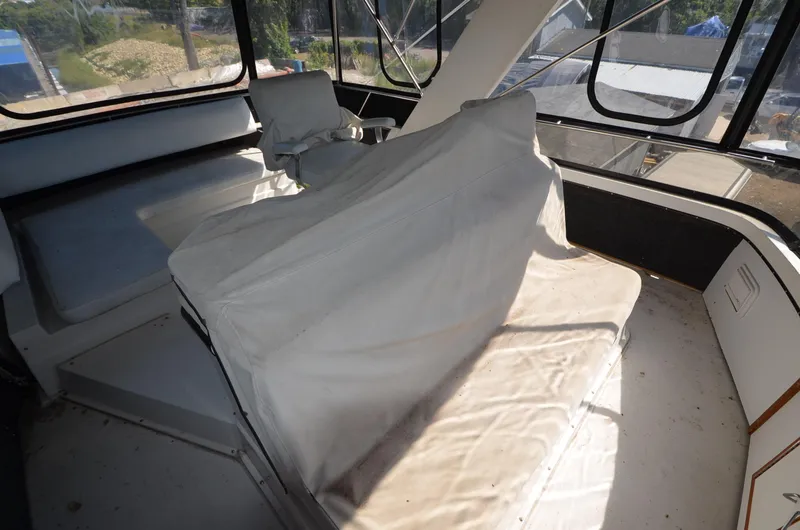 Slide: The Image of 1986 Carver Cockpit 4227 MY interior with covered seating and large windows. - 12