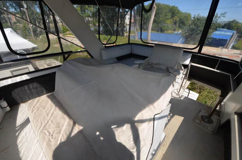 Slide: The Image of 1986 Carver Cockpit 4227 MY interior with covered seating and large windows. - 13