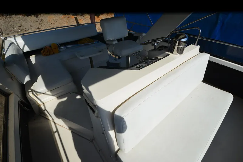 Slide: The Image of 1986 Carver Cockpit 4227 MY boat interior with white seating and steering area. - 26