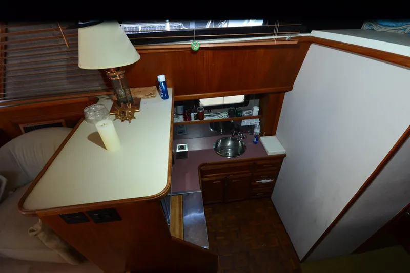 Slide: The Image of 1986 Carver Cockpit 4227 MY interior with kitchenette and wooden cabinetry. - 33