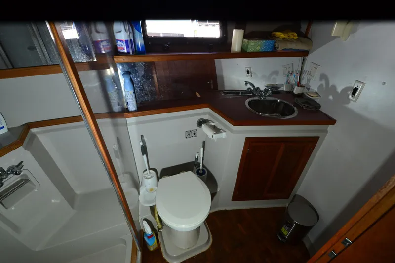 Slide: The Image of 1986 Carver Cockpit 4227 MY bathroom with sink, toilet, and storage cabinets. - 37