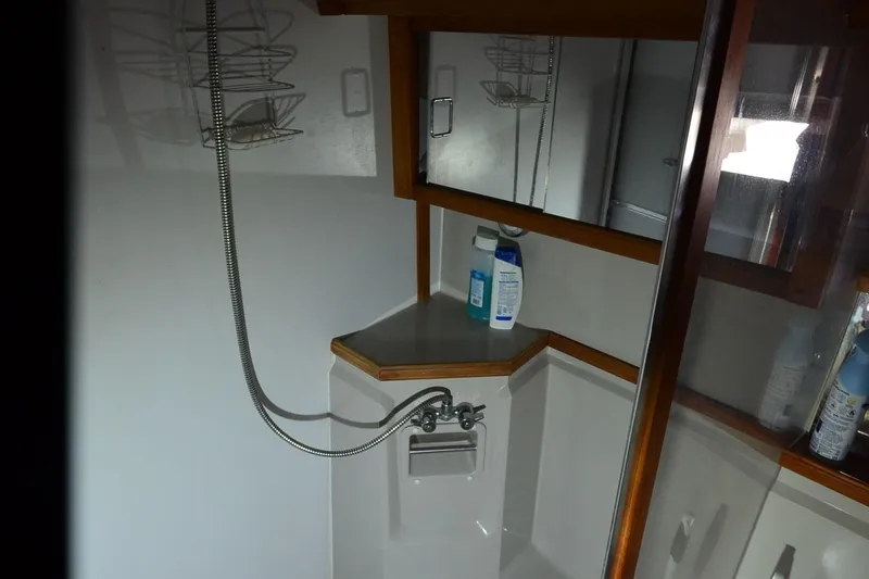 Slide: The Image of 1986 Carver Cockpit 4227 MY bathroom with shower, mirror, and toiletries. - 38