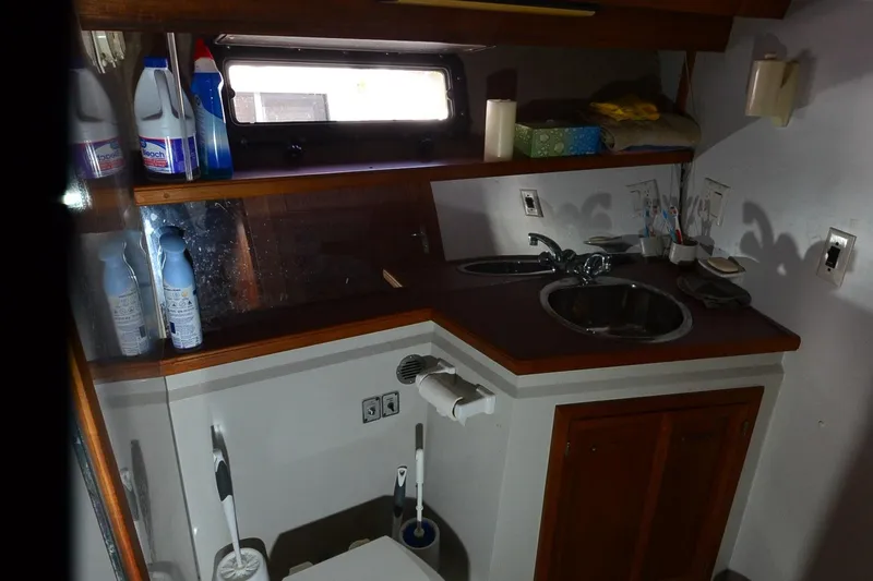 Slide: The Image of 1986 Carver Cockpit 4227 MY boat bathroom with sink, cleaning supplies, and storage cabinets. - 39