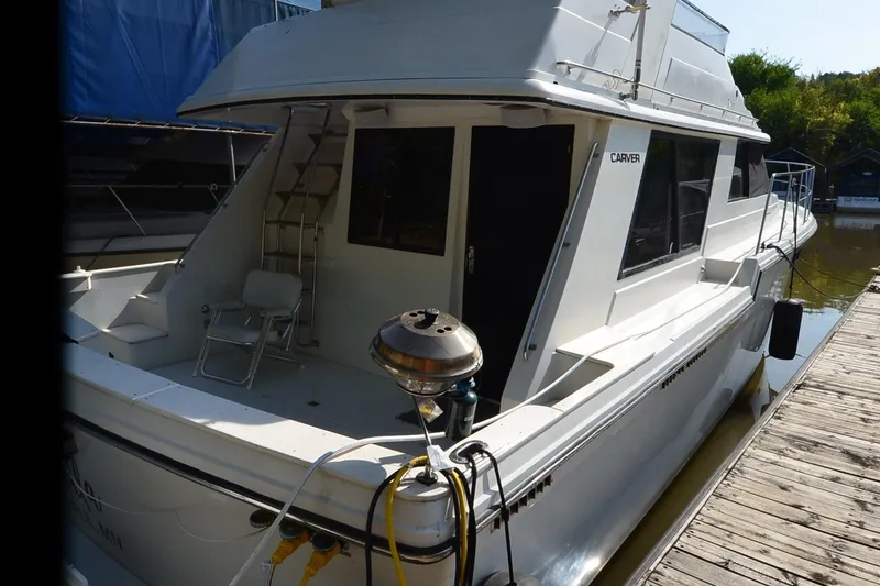Slide: The Image of 1986 Carver Cockpit 4227 MY yacht docked, featuring spacious deck and sleek design. - 4