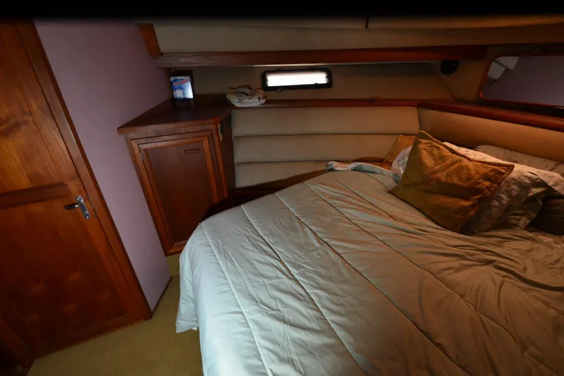 Slide: The Image of Cozy bedroom interior of 1986 Carver Cockpit 4227 MY yacht with wooden cabinetry. - 42