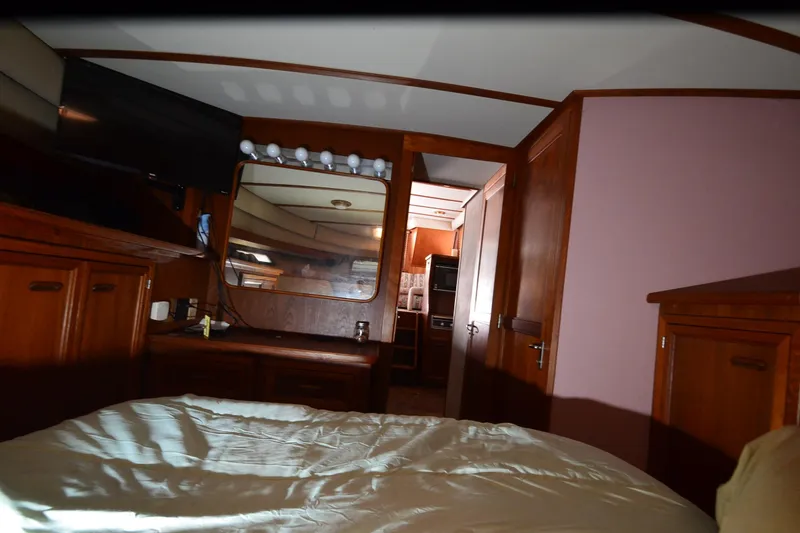 Slide: The Image of Interior of 1986 Carver Cockpit 4227 MY yacht, featuring wood cabinetry and cozy bedroom. - 43