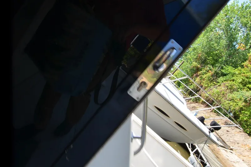 Slide: The Image of 1986 Carver Cockpit 4227 MY yacht docked near lush greenery. - 44