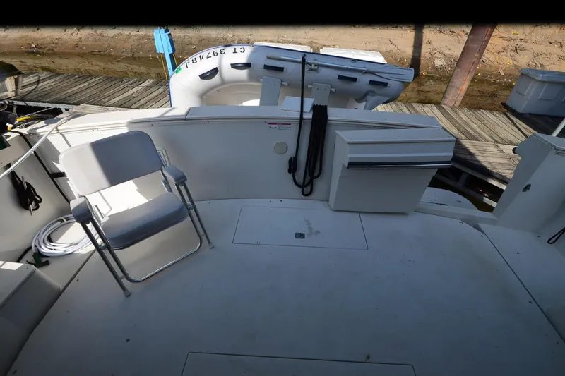 Slide: The Image of 1986 Carver Cockpit 4227 MY boat deck with chair and docked inflatable boat. - 51
