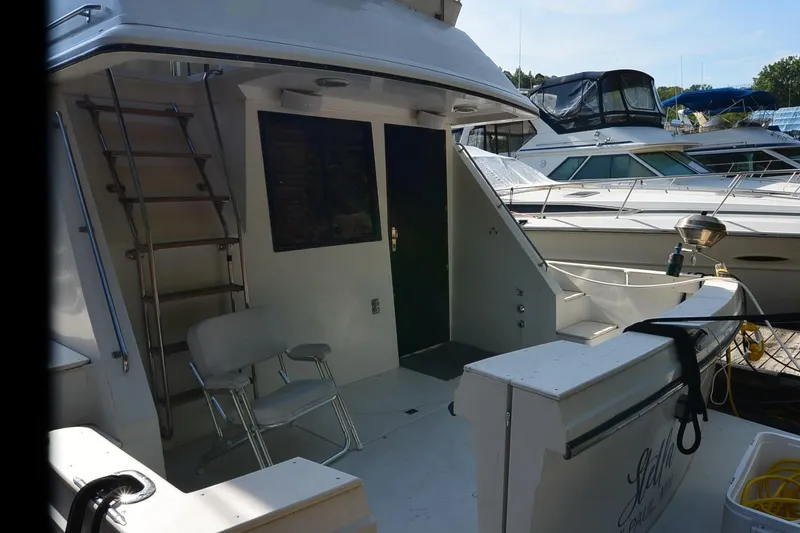 Slide: The Image of 1986 Carver Cockpit 4227 MY yacht docked, featuring a ladder and seating area. - 52