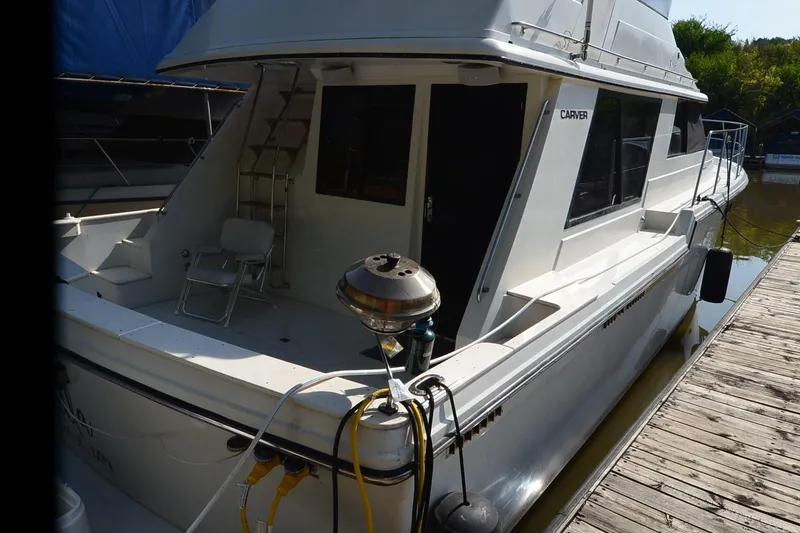 Slide: The Image of 1986 Carver Cockpit 4227 MY yacht docked, featuring spacious deck and sleek design. - 54