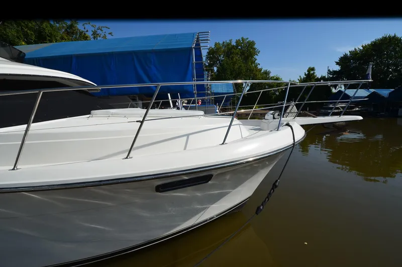 Slide: The Image of 1986 Carver Cockpit 4227 MY yacht docked on calm water, featuring sleek white design. - 55
