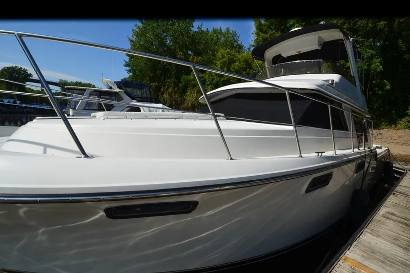 Slide: The Image of 1986 Carver Cockpit 4227 MY yacht docked, featuring sleek white design and spacious deck. - 56