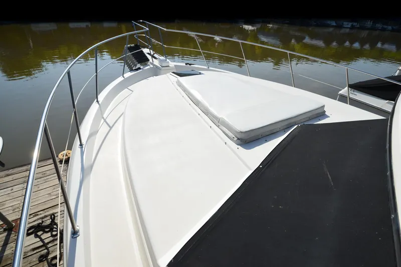 Slide: The Image of 1986 Carver Cockpit 4227 MY yacht deck with railing, docked by calm water. - 58