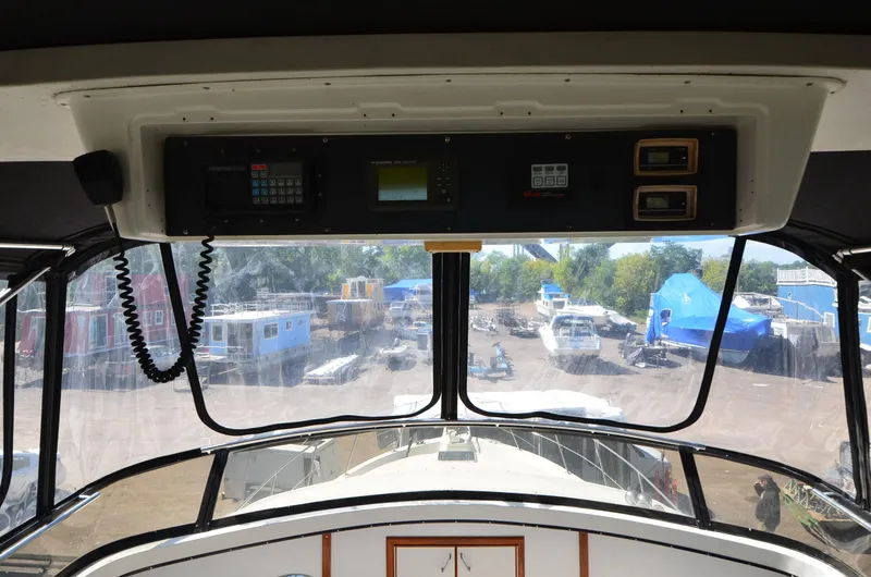 Slide: The Image of Interior view of 1986 Carver Cockpit 4227 MY yacht, showing control panel and marina. - 7