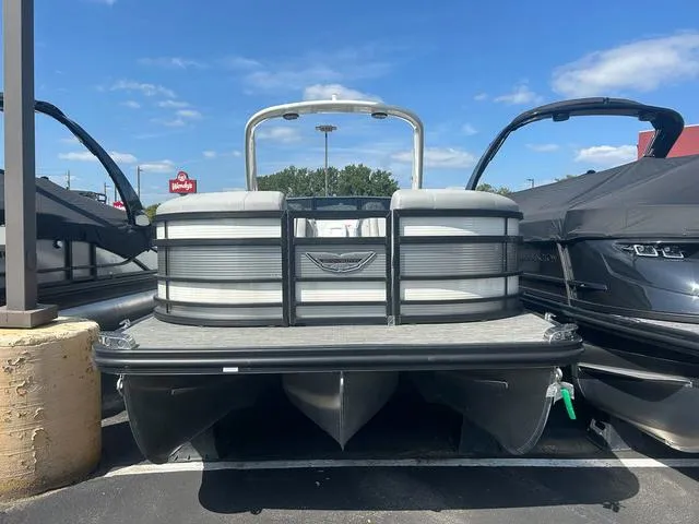 Slide: The Image of 2023 Bennington 25 RFBWA Tritoon boat with quad bench, parked outdoors. - 1