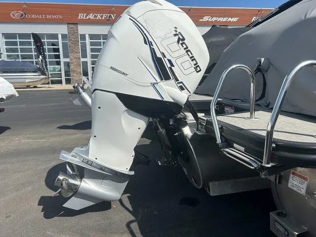 Slide: The Image of 2023 Bennington 25 RFBWA Tritoon with Mercury outboard motor, parked at a boat dealership. - 24