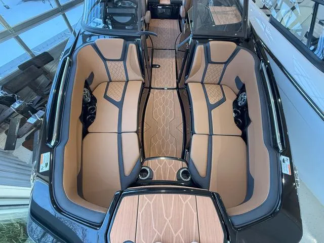 Slide: The Image of 2025 Yamaha Boats 255XD interior with tan and black seating, modern design, and spacious layout. - 23