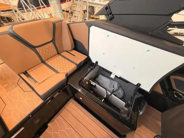 Slide: The Image of 2025 Yamaha Boats 255XD interior with open storage compartment and tan seating. - 8