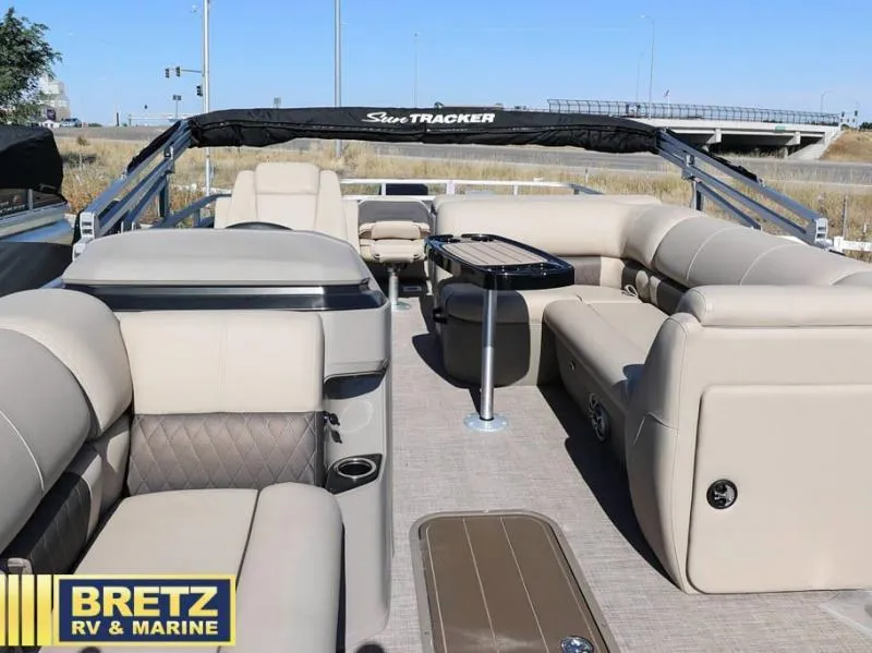 Slide: The Image of 2024 Fishin' Barge 22 XP3 pontoon boat interior with beige seating and table. - 10