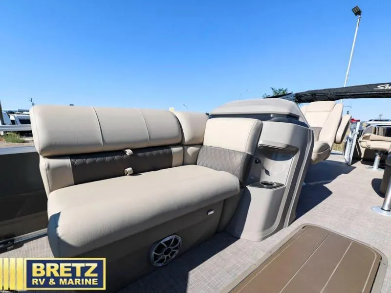 Slide: The Image of 2024 Fishin' Barge 22 XP3 pontoon boat interior with beige seating and cup holders. - 11