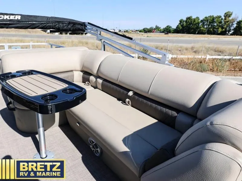 Slide: The Image of 2024 Fishin' Barge 22 XP3 pontoon boat interior with beige seating and table. - 12