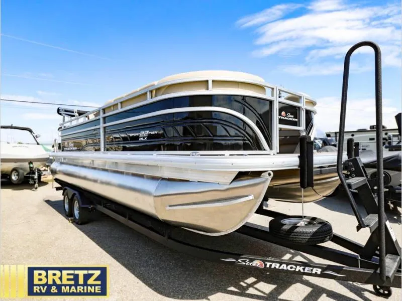 Slide: The Image of 2024 Sportfish 22 DLX pontoon boat on trailer at Bretz RV & Marine dealership. - 1