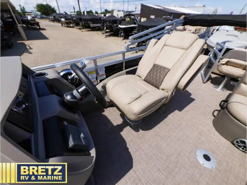 Slide: The Image of 2024 Sportfish 22 DLX boat interior with beige captain's chair and steering console. - 11