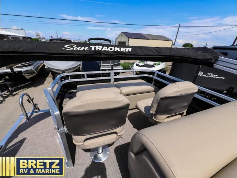 Slide: The Image of 2024 Sportfish 22 DLX pontoon boat with beige seating, displayed at Bretz RV & Marine. - 14