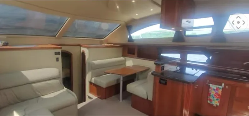 Slide: The Image of 2005 Cruisers Yachts 405 Express Motoryacht interior with seating, table, and kitchen area. - 13