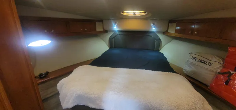 Slide: The Image of 2005 Cruisers Yachts 405 Express Motoryacht cabin with bed, storage, and life jackets. - 14