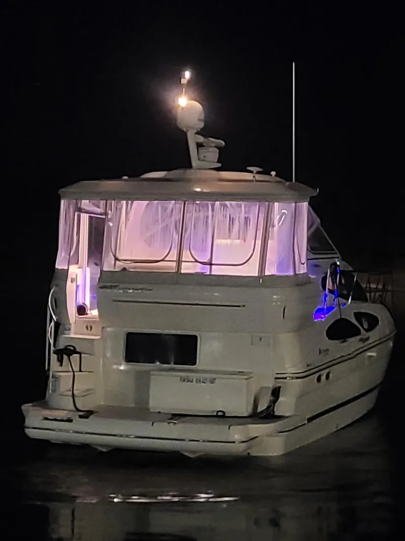 Slide: The Image of 2005 Cruisers Yachts 405 Express Motoryacht illuminated at night on the water. - 19
