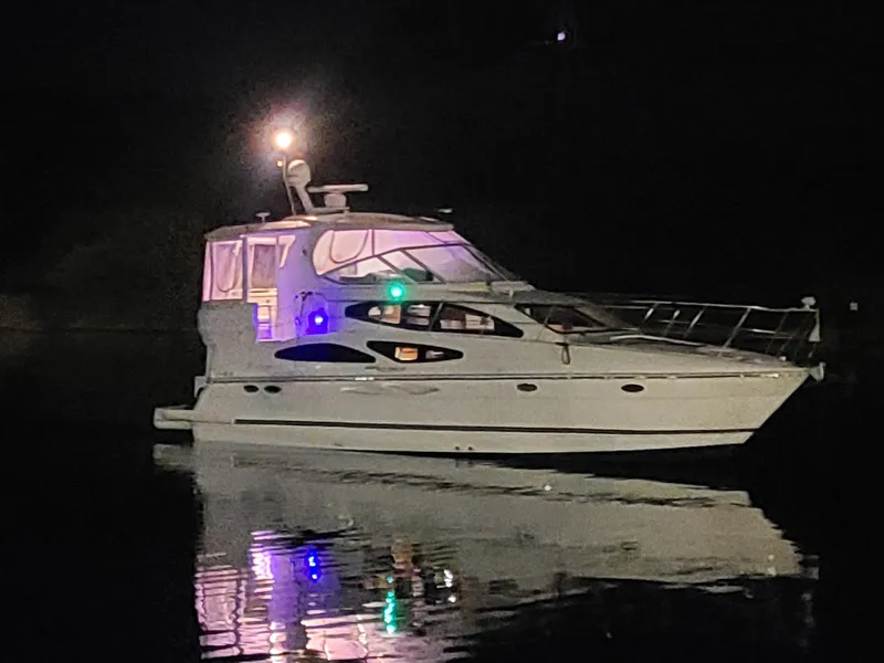 Slide: The Image of 2005 Cruisers Yachts 405 Express Motoryacht illuminated at night on calm water. - 20